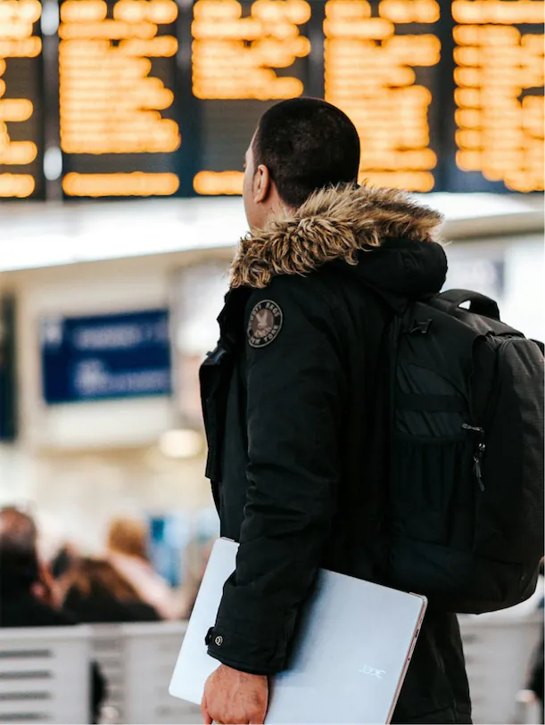 The hand guy stands in the crowded airport lobby. He looks confused and might be deported. He should do his immigration papers properly.